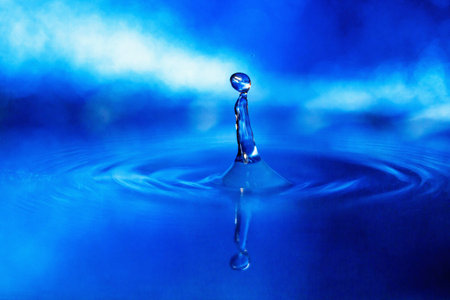 a drop of water on a blue background in smoky lightの写真素材