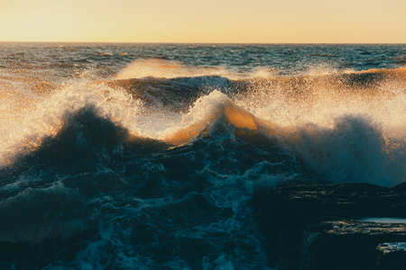 Monstrous sea storm waves in sunset warm raysの写真素材