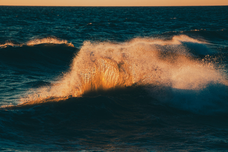 Monstrous sea storm waves in sunset warm raysの写真素材