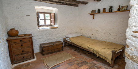 This rustic bedroom showcases a wooden bed, chest, and a simple window with wooden shutters. The muted colors and natural materials create a warm, inviting atmosphere.の素材