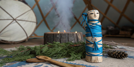 A beautifully crafted wooden figure wrapped in blue ribbon stands beside a flickering fire inside a yurt. Fresh greenery and natural elements surround it, creating a warm atmosphere.の写真素材