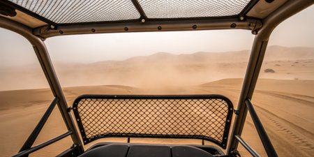 A thrilling ride in an off-road vehicle captures the view of expansive sandy dunes and swirling dust. The sun blazes overhead as the landscape stretches into the horizon.の写真素材