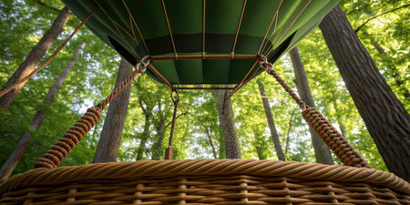 A colorful hot air balloon floats above a vibrant green forest, capturing the essence of adventure and nature. Sunlight filters through the leaves, creating a serene atmosphere.の写真素材