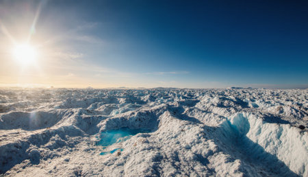 Vast stretches of ice and snow shimmer under the bright sunlight, creating a stunning winter landscape. The horizon reveals layers of ice formations, glistening in the serene atmosphere.の写真素材