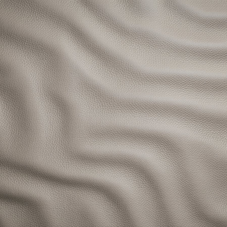 A soft beige surface displays gentle waves and curves, revealing a soothing texture. Light plays across the ripples, creating a calming and inviting atmosphere.の写真素材