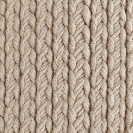 A close-up view of thick knit fabric showcasing a repetitive braided design in a soft beige color....