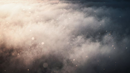 Soft clouds blanket the sky as the sun sets, casting a warm glow over the horizon. Tiny specks of light shimmer, creating a magical and peaceful atmosphere that invites reflection.の写真素材