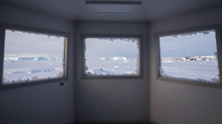 Inside a cozy shelter, three frosted windows reveal a breathtaking scene of an icy landscape. Snow...