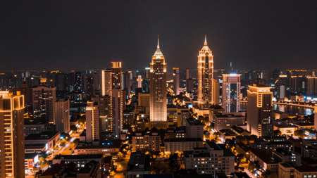 Bright city lights twinkle in the night sky as towering buildings stand tall. Streets are alive with vibrant energy, showcasing urban life and architectural beauty in a bustling metropolis.の写真素材