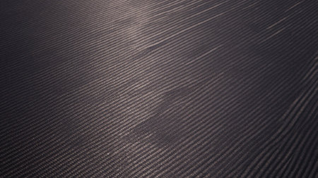 View of a dark carbon fiber texture, featuring a grid pattern composed of thin, evenly.