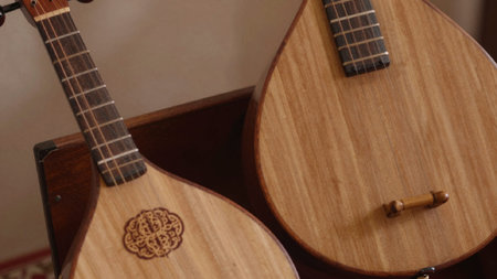 Photograph of two musical instruments, one on the left and the other on the right, both made of...