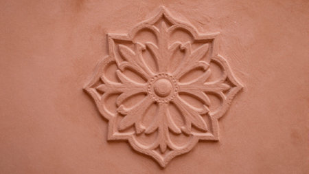 Photograph of a decorative, carved relief on a stucco wall. The relief is in the shape of a...