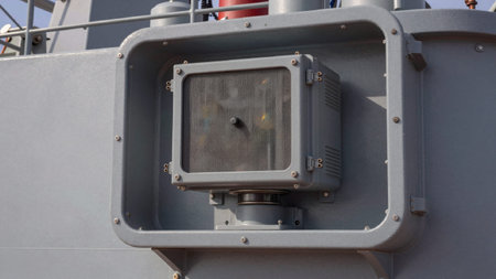 Photograph of an industrial enclosure mounted on the side of a ship, the enclosure is rectangular in...