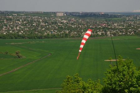 Air field direction sign and a wind force windsock against the  blue sky with clouds.の写真素材
