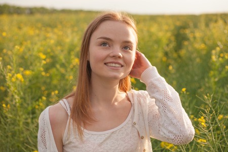 woman with open arms in the green wheat field at the morning.の写真素材