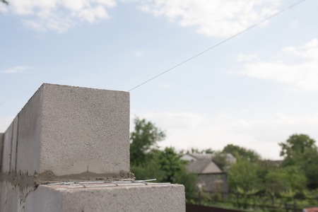 worker aligns with a spatula, lay brick cinderblocks.の写真素材