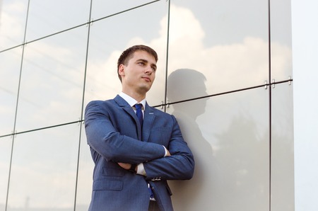 young successful man economist standing in modern office interior, confident male dressed in luxury...