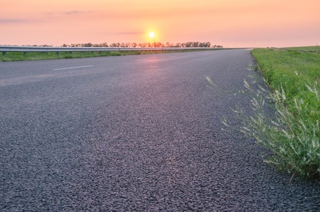 Empty asphalt road to pink beautiful sunsetの写真素材