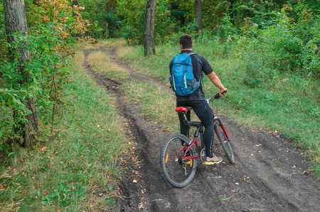 Mountainbiker riding on bicycle in summer park at sunny day