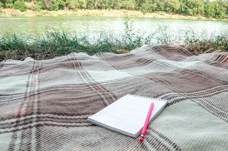 notebook with pencil and notes on space green grass in flat layの写真素材