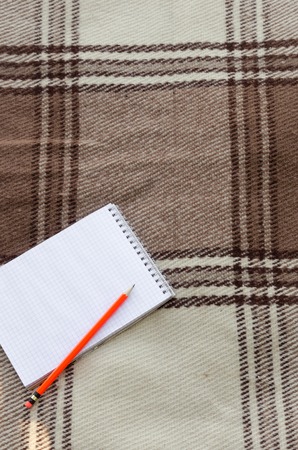 notebook with pencil and notes on coverlet in flat layの写真素材