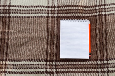 notebook with pencil and notes on coverlet in flat layの写真素材