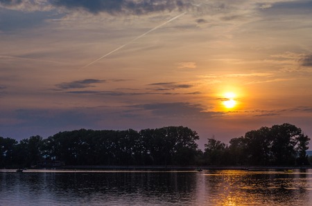 Beautiful bright cloudy sunset above the lakeの写真素材