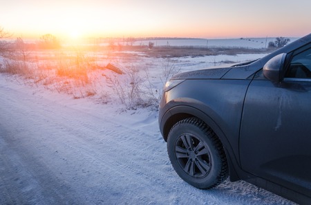 crossover goes on the road along lake in winterの写真素材