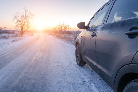 crossover goes on the road along lake in winterの写真素材
