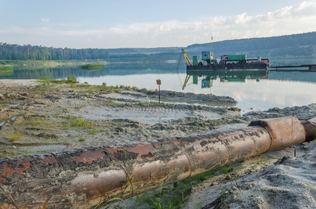 exavation machine excavator at earthmoving work in sand quarry. Extraction of sand from a sand pit. Iron technological constructions.の写真素材