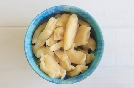 In blue ceramic dish, fruit and berry dumplings with cherries. Fresh cherry dumplings for bank. Sour cream for dumplings with cherries. Gray wooden backgroundの写真素材