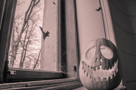 Creepy halloween scary pumpkin with a smile at the old wooden background doors.の写真素材