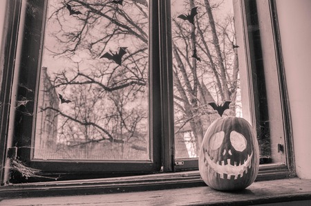 Creepy halloween scary pumpkin with a smile at the old wooden background doors.の写真素材