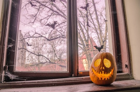 Creepy halloween scary pumpkin with a smile at the old wooden background doors.の写真素材