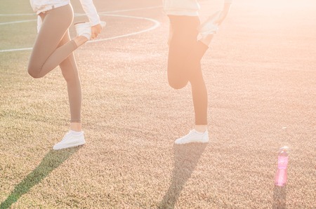 Energetic girl friends on a fitness training on a park background. Sport and stretches concept. Copy spaceの写真素材