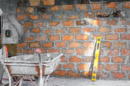 wall by red bricks with tools: level, cart, hammerの写真素材
