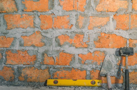 Mason bricklaying background with level, hammer and clay brick blocksの写真素材