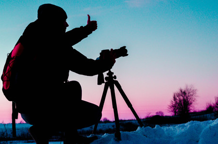 Silhouette of a photographer like to travel and photography, taking pictures of the beautiful moments during the sunset ,sunriseの写真素材