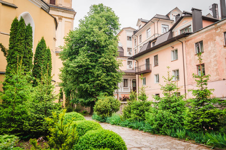 Path crossing flowered yard with people and old building in the Garden of Plants in Paris.の写真素材