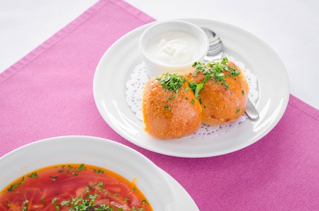 Ukrainian borsch soup and garlic buns on the table. Horizontal view from aboveの写真素材