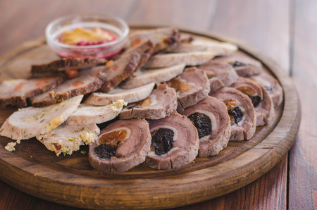 Different kinds of meat rolls on a wooden plateの写真素材