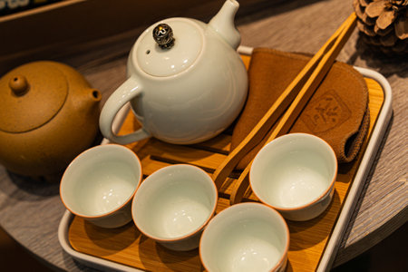 Tea ceremony setup with teapot, cups, and utensils on a bamboo trayの写真素材
