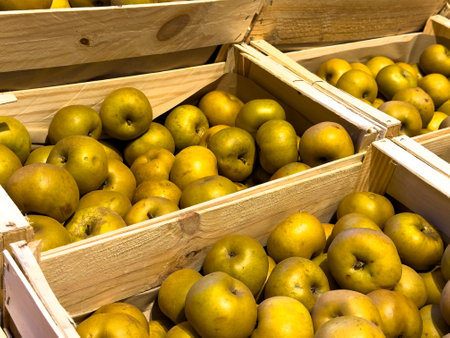 Freshly harvested apples displayed in wooden crates at a local farmers market in autumnの写真素材