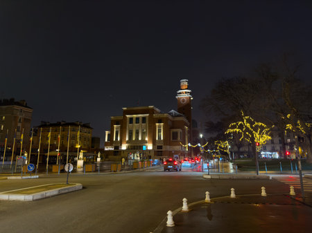Nighttime view of a historic building illuminated with holiday lights in a bustling urban areaの写真素材