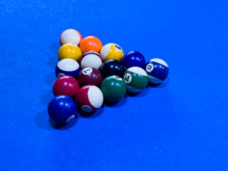 Colorful billiard balls arranged on a blue pool table before a gameの写真素材