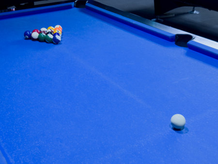 Eye on the game as the cue ball awaits its destiny on the blue pool table