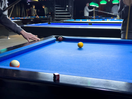 Players enjoy a lively pool game in a vibrant indoor bar atmosphereの写真素材