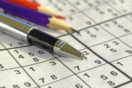 Sudoku game and a ball pen on the tableの写真素材