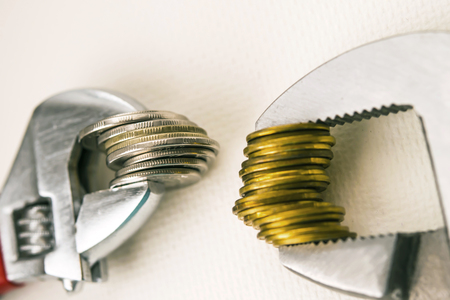 The concept of financial reliability. Wrenches and coins. The concept of financial reliability.の写真素材