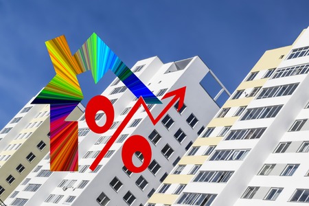Red percent sign on the background of houses. The concept of price changes on the real estate market.の写真素材